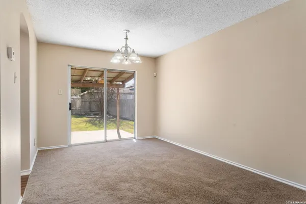 an empty room with a windows and chandelier