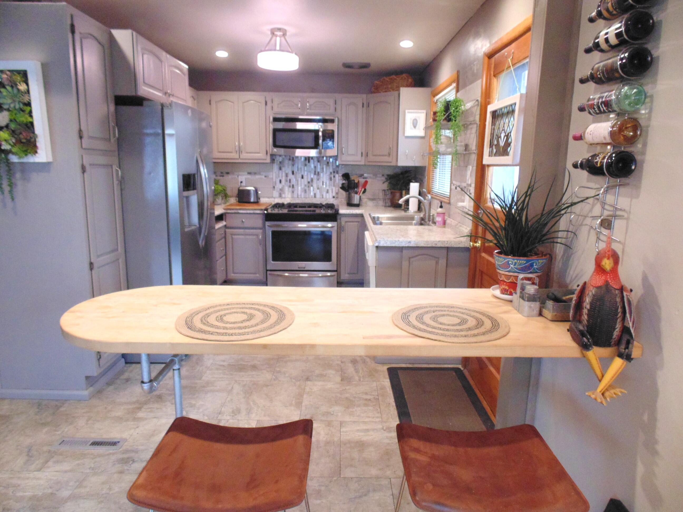 6801 Forest Avenue Gary, IN 46403 - Photo 9 of 23 a kitchen with stainless steel appliances kitchen island granite countertop a dining table chairs and couches