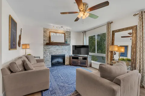 a living room with furniture a flat screen tv and a fireplace
