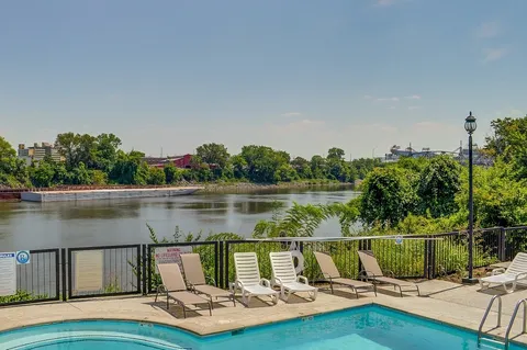 a view of a lake with a table and chairs next to a yard