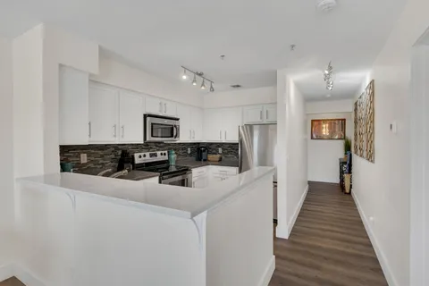 a kitchen with stainless steel appliances a refrigerator sink stove microwave and cabinets