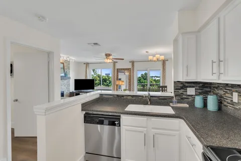 a kitchen with stainless steel appliances granite countertop a sink and a refrigerator