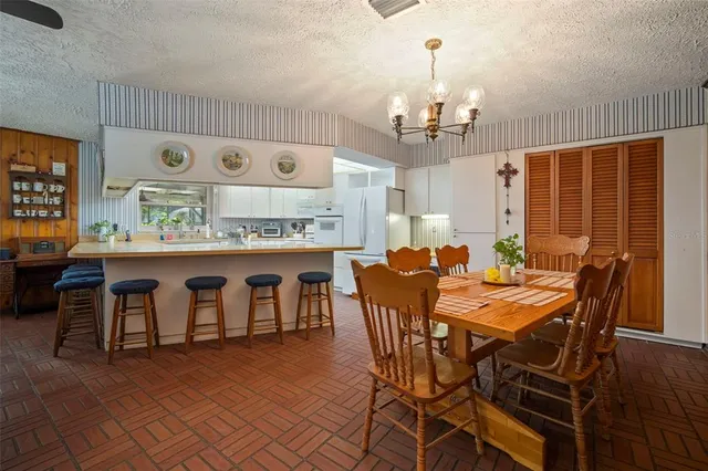 a view of a dining room with furniture and chandelier
