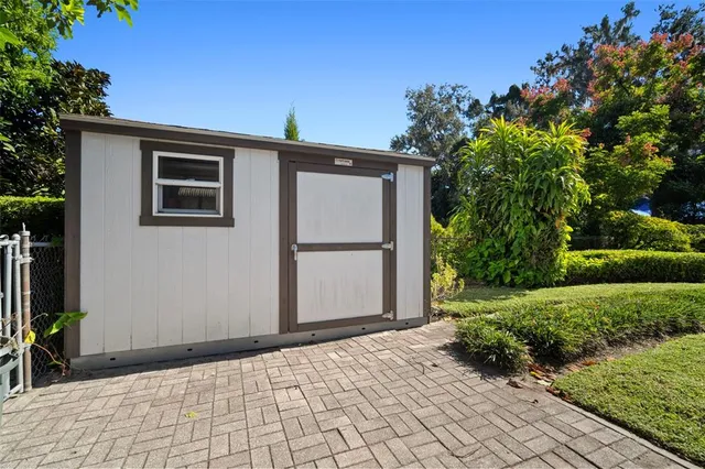 a view of a backyard with lawn chairs potted plants and a palm tree