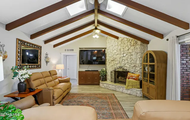 a living room with furniture a flat screen tv and a fireplace