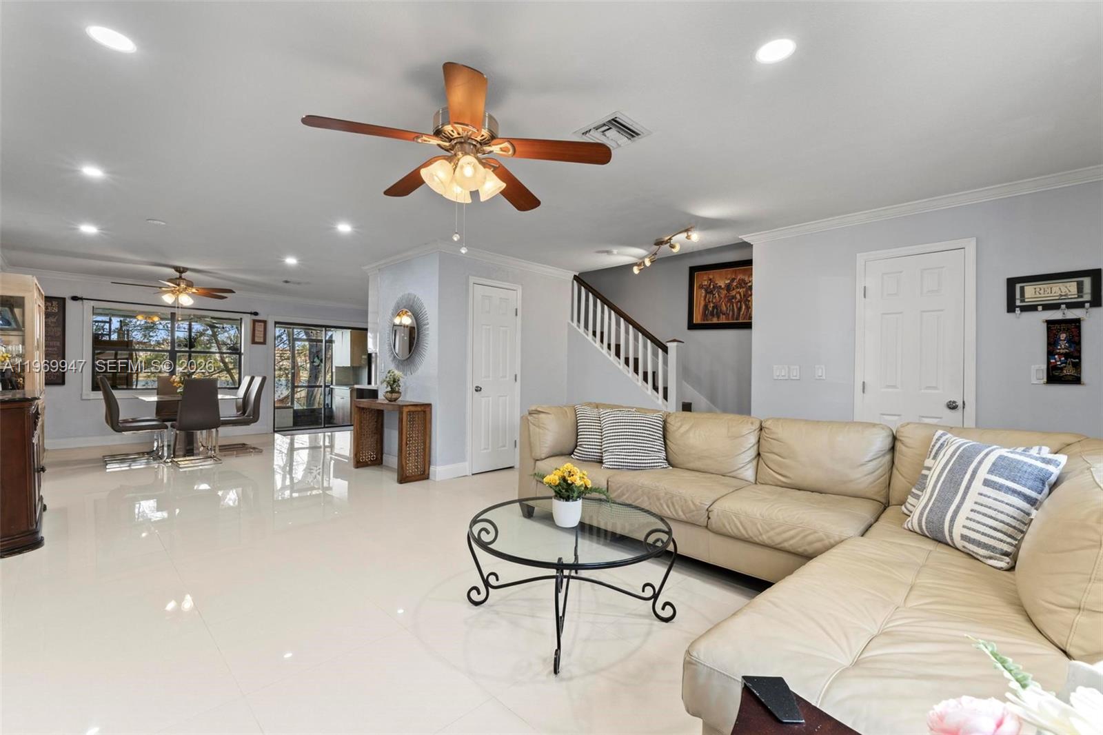 a living room with furniture kitchen view and a chandelier