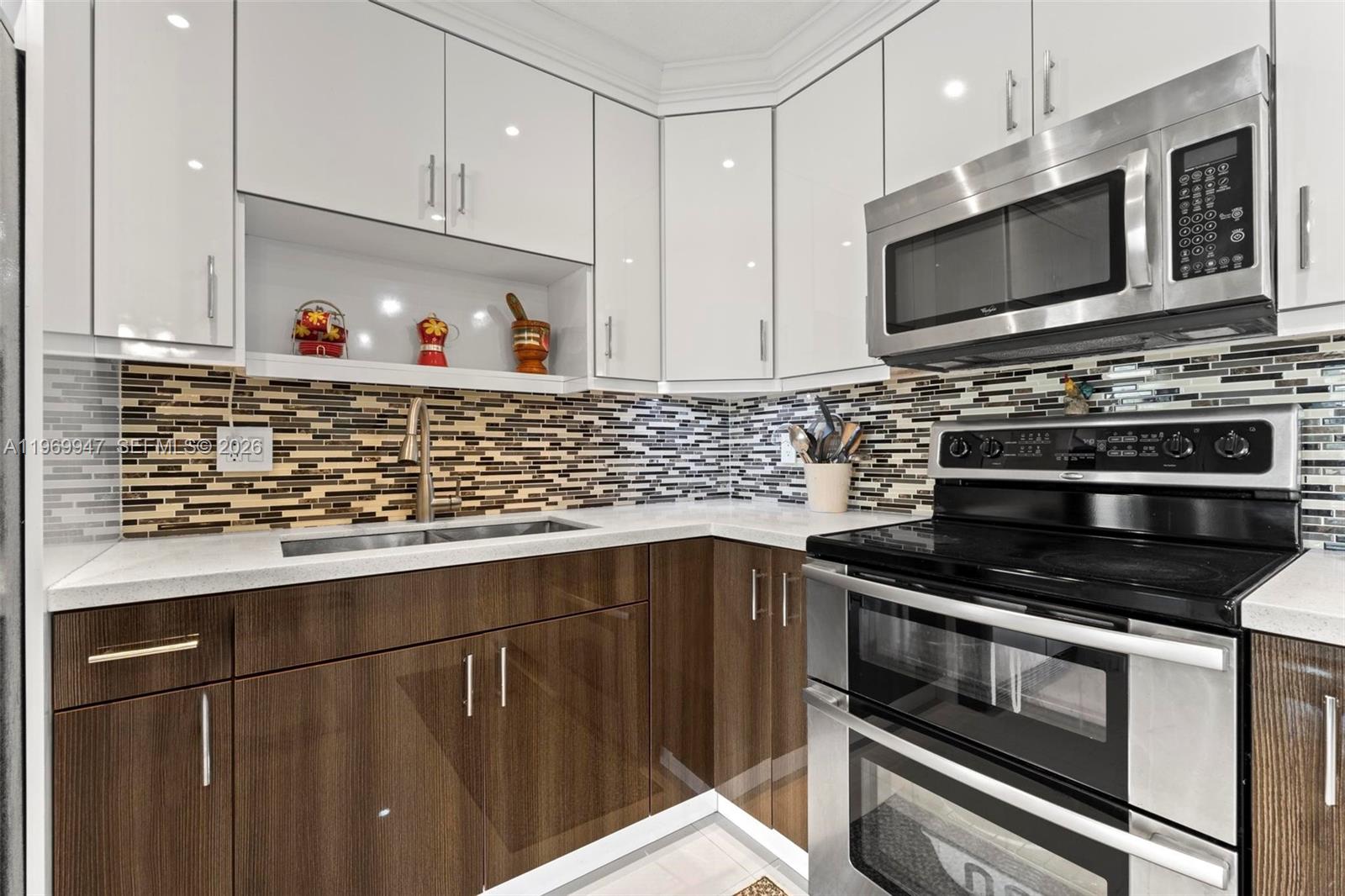 3370 Beau Rivage Drive, Unit B8 Pompano Beach, FL 33064 - Photo 15 of 33 a kitchen with stainless steel appliances a stove a microwave and a sink