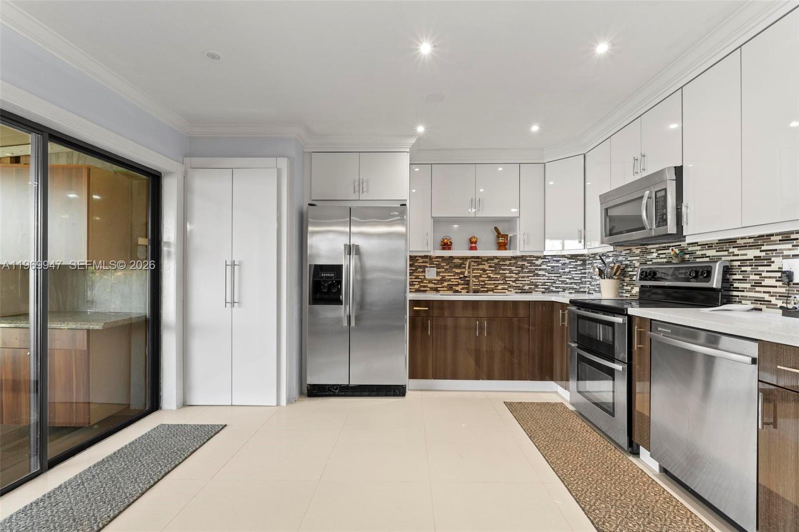 3370 Beau Rivage Drive, Unit B8 Pompano Beach, FL 33064 - Photo 2 of 33 a kitchen with stainless steel appliances granite countertop a refrigerator and a stove top oven