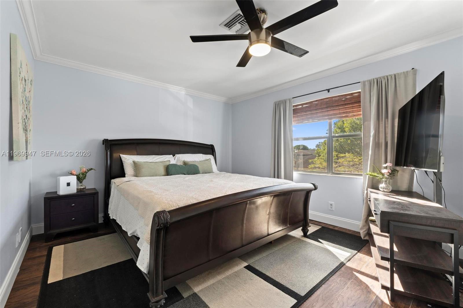 3370 Beau Rivage Drive, Unit B8 Pompano Beach, FL 33064 - Photo 3 of 33 a bedroom with a bed and a flat screen tv