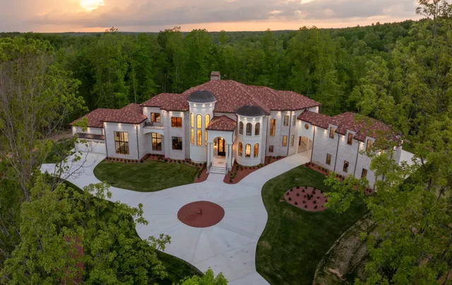 a aerial view of a house with yard and green space