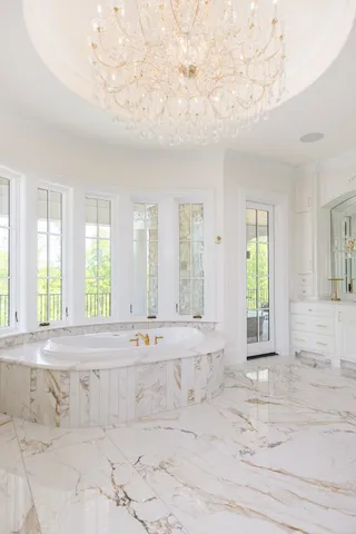 a view of an empty room with large windows and a fireplace