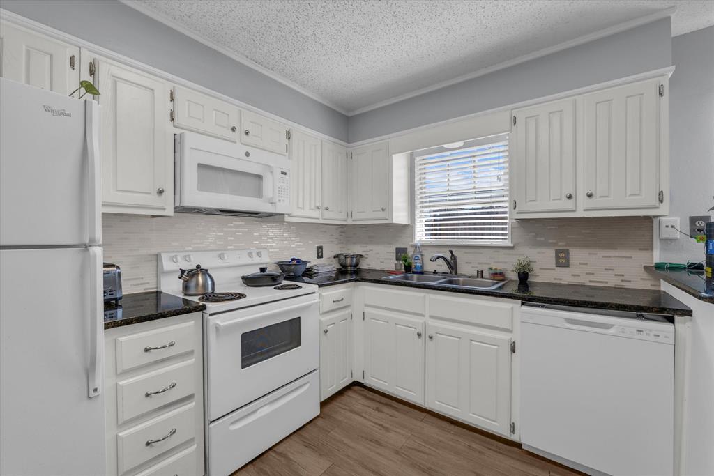 1349 South 11th Street Waco, TX 76706 - Photo 4 of 17 a kitchen with granite countertop white cabinets white appliances and a sink