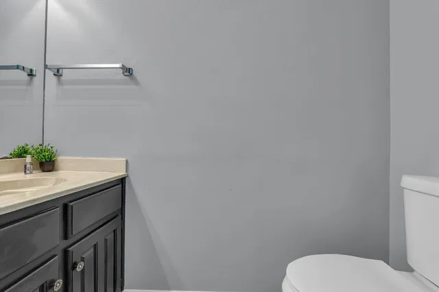 a bathroom with a granite countertop toilet and sink