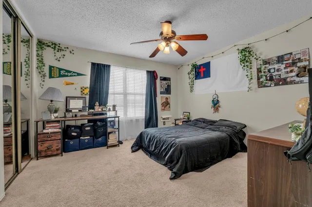a bedroom with a bed and dresser with mirror
