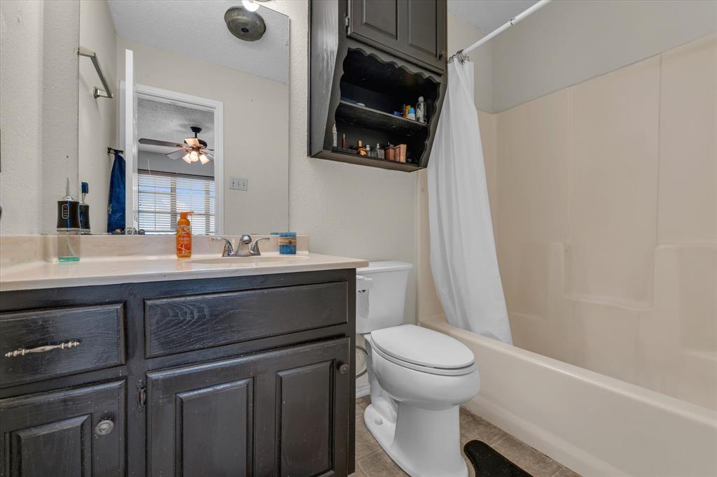 1349 South 11th Street Waco, TX 76706 - Photo 10 of 17 a bathroom with a sink a toilet a mirror and shower