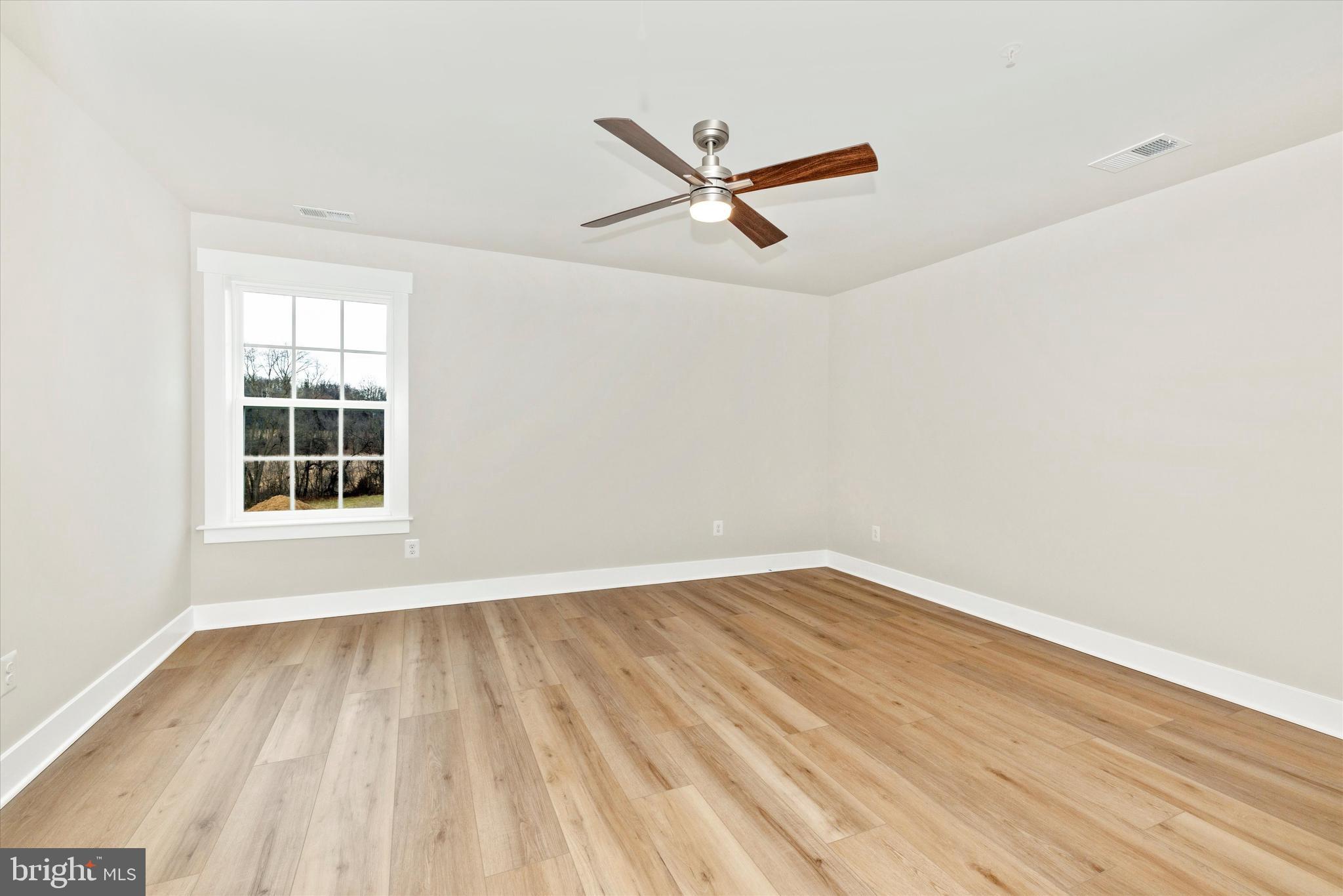 10230 Daysville Road Walkersville, MD 21793 - Photo 31 of 43 an empty room with wooden floor ceiling fan and windows