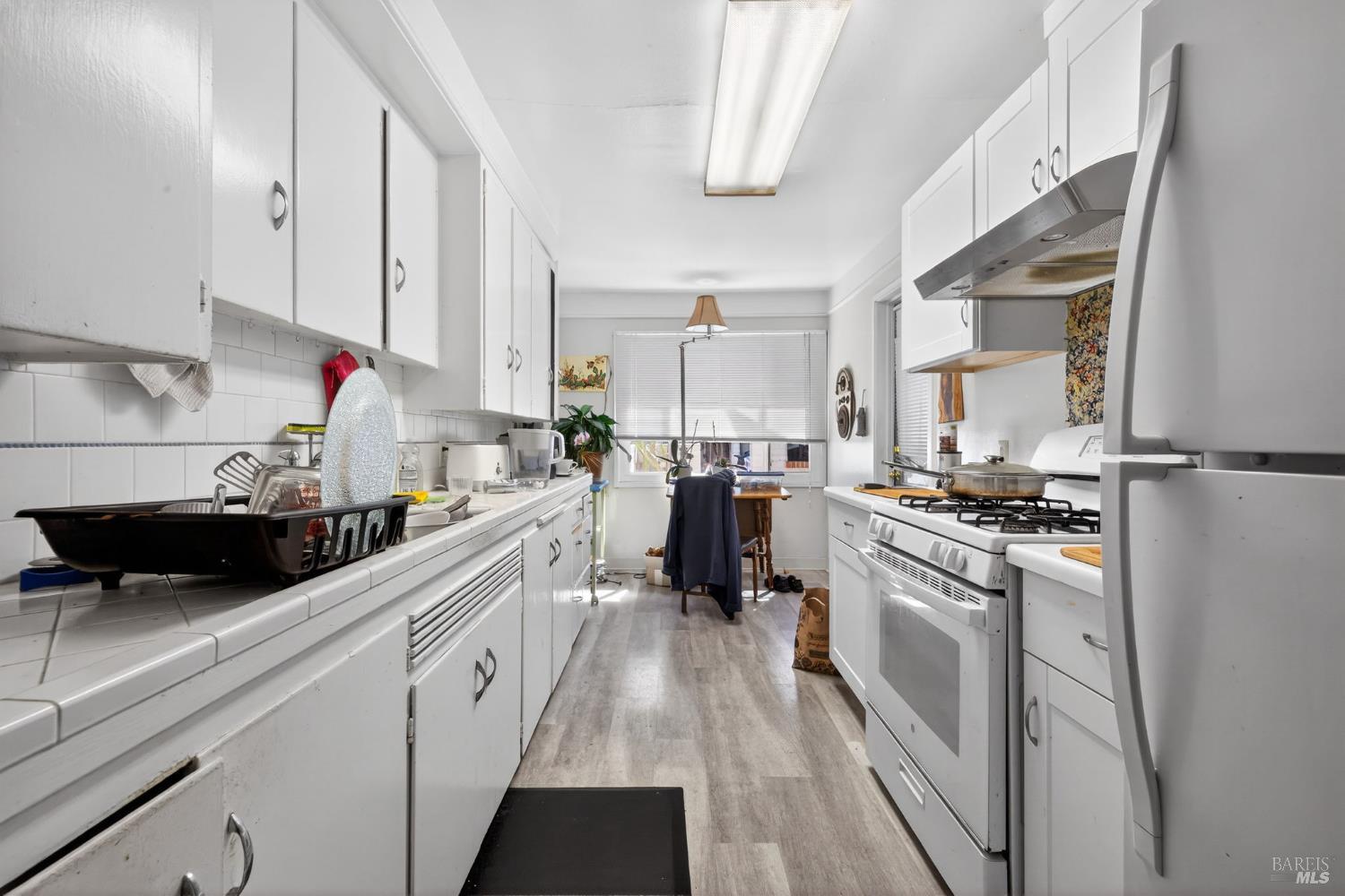1204 14th Street Santa Rosa, CA 95404 - Photo 8 of 26 1206 14Th Street, Light and bright kitchen with updated flooring, refrigerator and gas range.