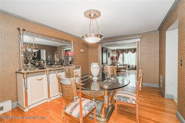a dining room with chandelier and wooden floor