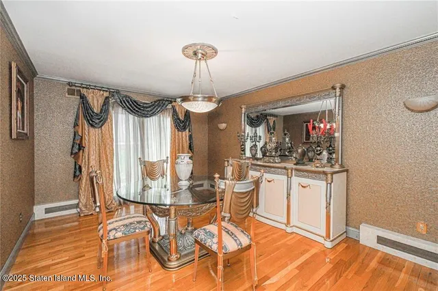 a view of a dining room with furniture a chandelier and wooden floor