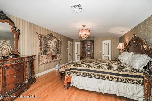 a bedroom with a bed and a dresser with mirror