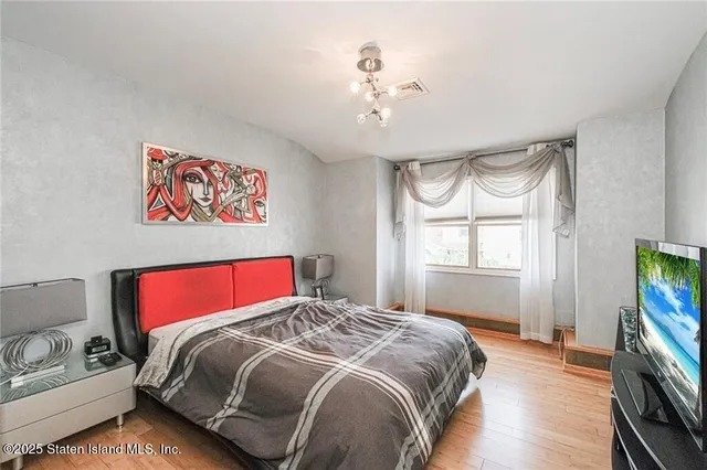 a bedroom with a bed and a flat screen tv