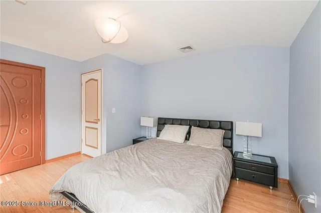 a bedroom with a bed and wooden floor