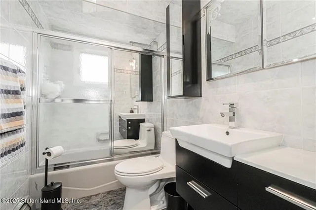 a bathroom with a sink a toilet a mirror and shower