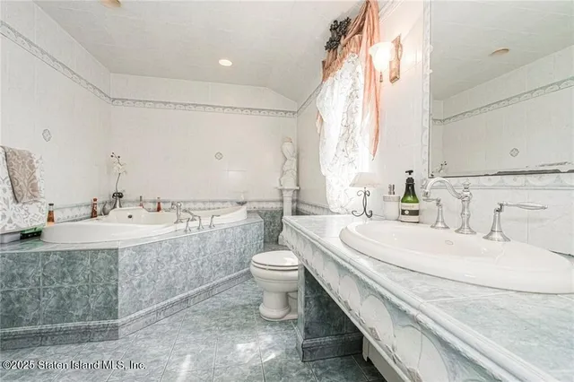 a bathroom with a double vanity sink toilet and a mirror