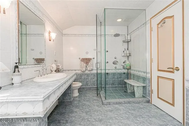 a bathroom with a double vanity sink toilet mirror and shower