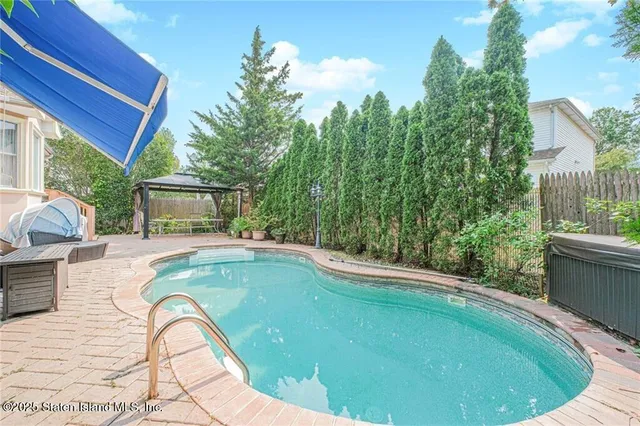 a view of a house with swimming pool and sitting area