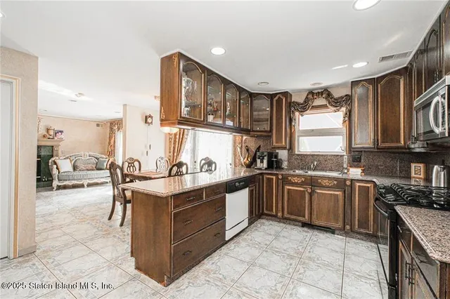 a kitchen with stainless steel appliances granite countertop a stove top oven a sink dishwasher and cabinets