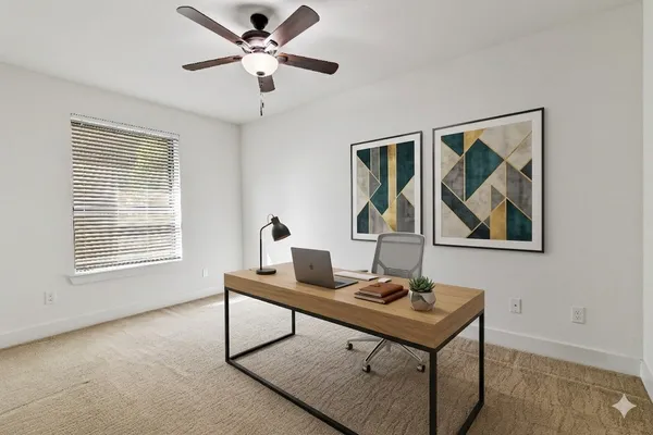 a view of a workspace with furniture and a window
