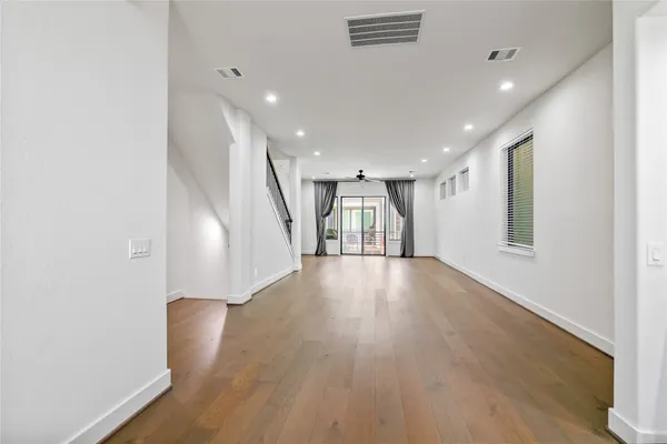 a view of empty room with wooden floor