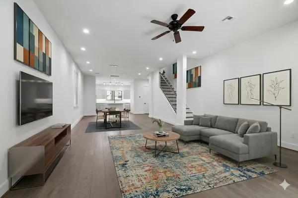 a living room with furniture and a flat screen tv with wooden floor