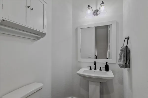 a bathroom with a sink a toilet and mirror