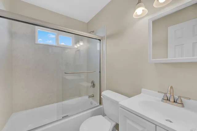 a bathroom with a bathtub shower sink vanity and toilet