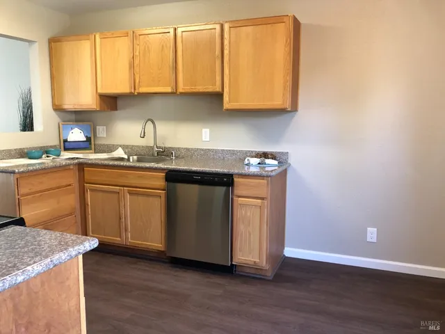 a kitchen with a sink cabinets and wooden floor