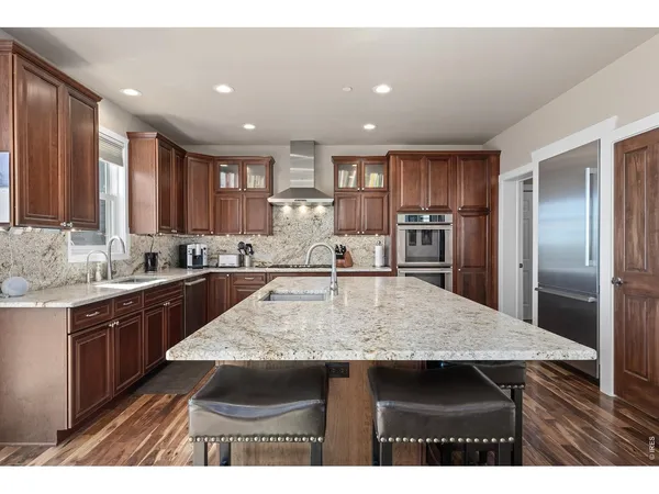 a kitchen with kitchen island a sink refrigerator and cabinets