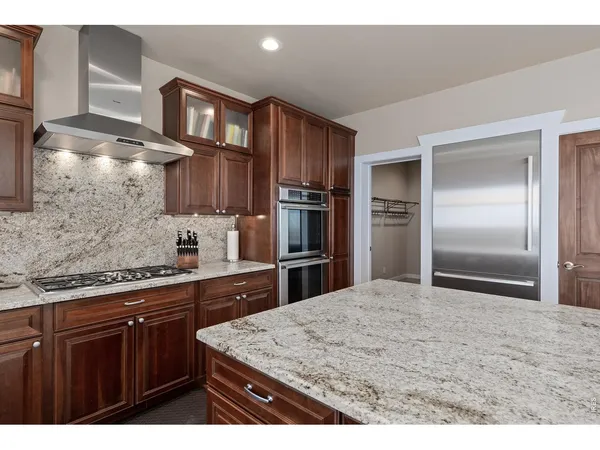 a kitchen with kitchen island a counter top space cabinets and stainless steel appliances
