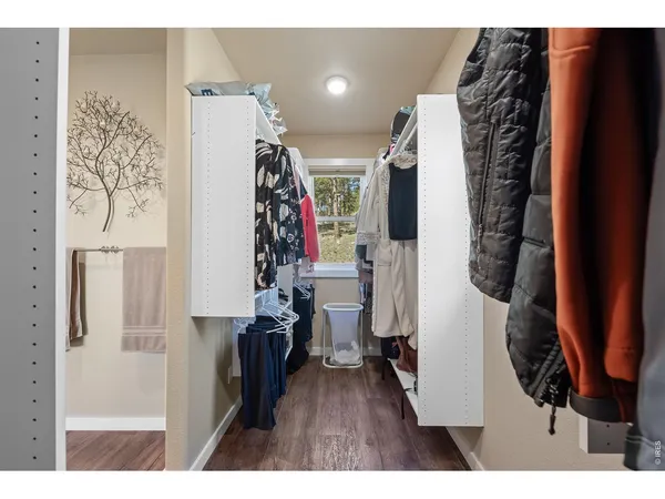 a view of walk in closet with clothes and shoes