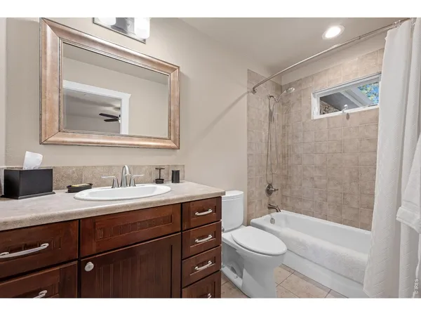 a bathroom with a granite countertop sink toilet a mirror and shower