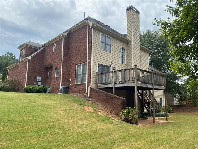 a view of a house with backyard and sitting area