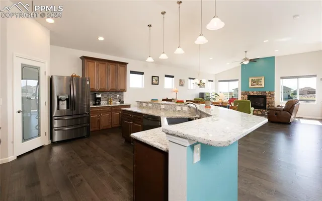 a kitchen with a refrigerator a sink dishwasher and a stove with wooden floor