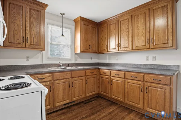 a kitchen with granite countertop wooden cabinets and white appliances