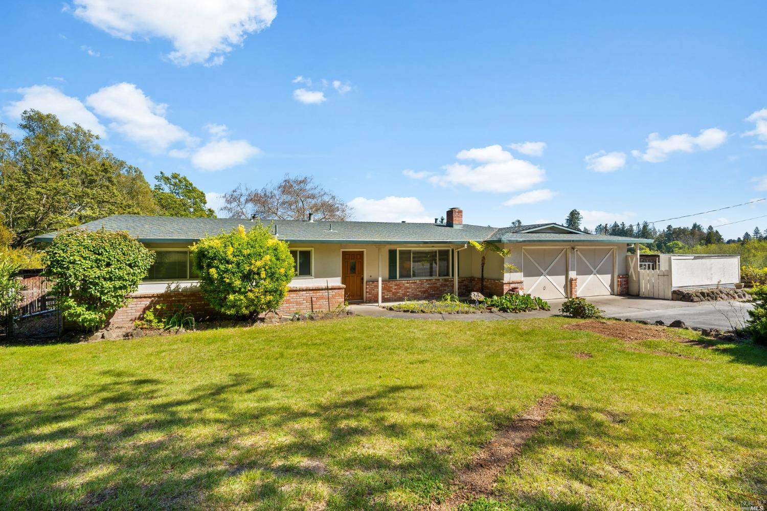 a view of a house with a big yard and potted plants