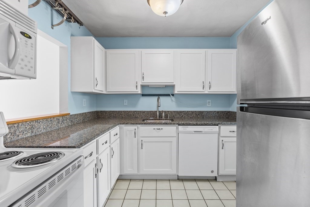 88 Gordon Street, Unit 204 Boston, MA 02135 - Photo 4 of 12 a kitchen with granite countertop a sink stove and cabinets