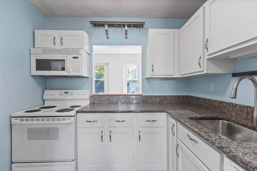 88 Gordon Street, Unit 204 Boston, MA 02135 - Photo 5 of 12 a kitchen with granite countertop white cabinets and a sink