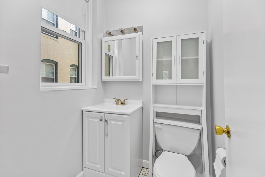 88 Gordon Street, Unit 204 Boston, MA 02135 - Photo 9 of 12 a bathroom with a toilet a sink and mirror