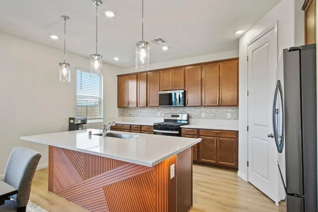 a kitchen with stainless steel appliances granite countertop a sink refrigerator and cabinets