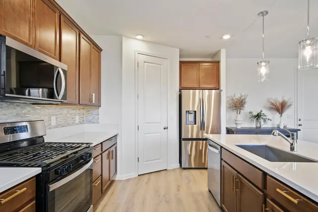 a kitchen with stainless steel appliances granite countertop a sink stove and refrigerator